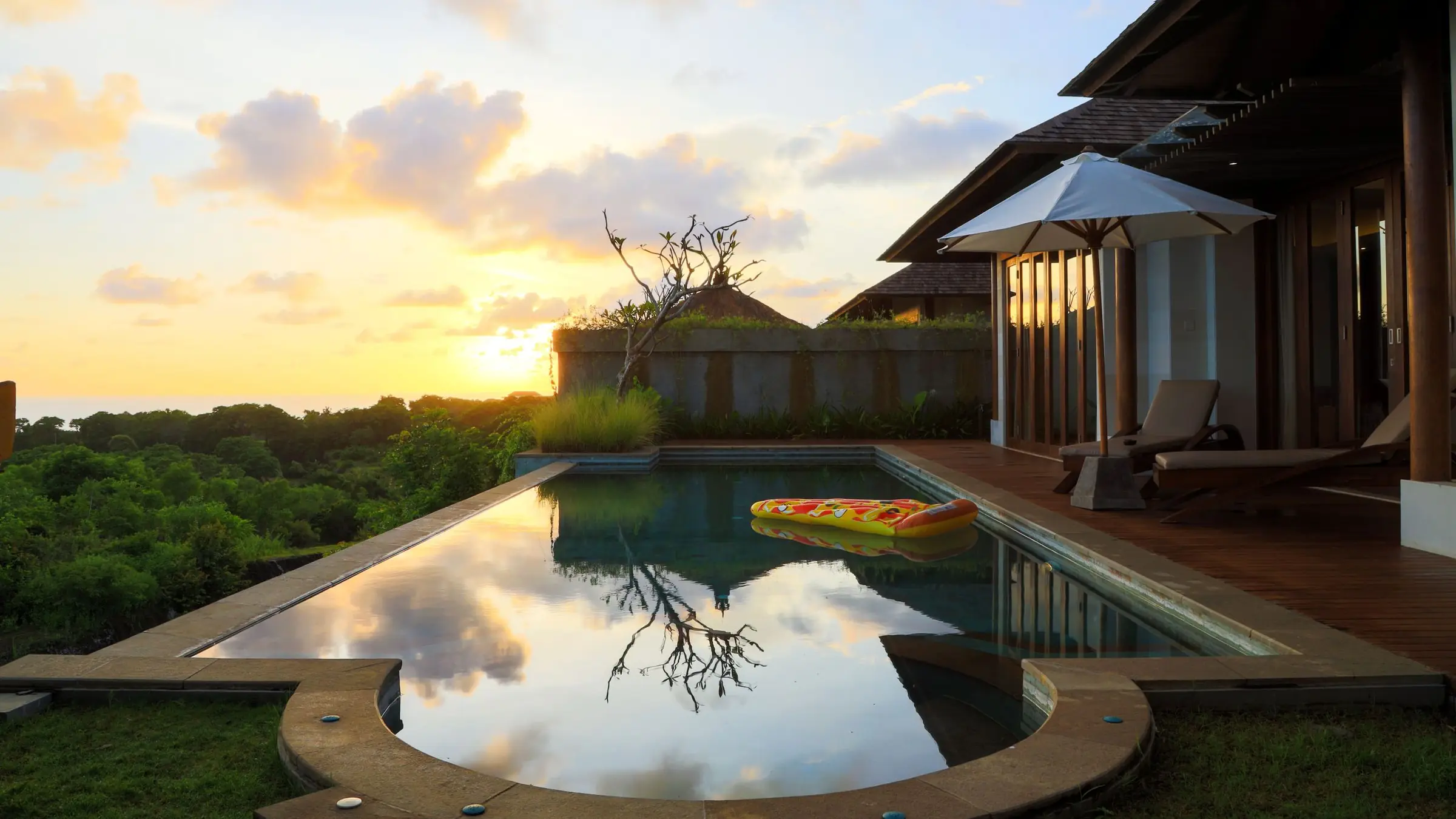 Villa with a reflecting pool and a clay-tile roof at sunset